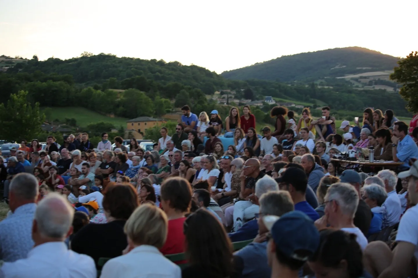 Le public du festival au coucher du soleil dans les collines